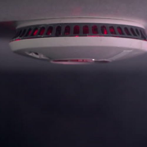 Stock HD video clip footage of a Smoke Alarm going off and flashing after detecting smoke - Red flashing lights - DOLLY motion